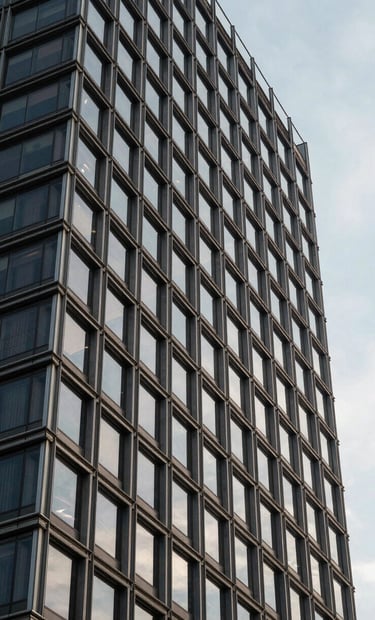 Architectural detail of a modern corporate building in Brazil. Steel and glass construction reflecting a pale blue-grey sky. The image conveys a forward-thinking and sophisticated brand identity.