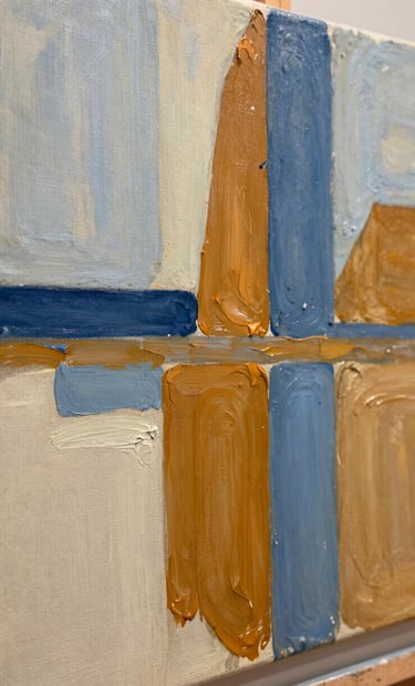A close-up photograph of an experimental oil painting on a textured linen canvas. The artwork features bold, expressive strokes of slate blue and warm ochre over a soft alabaster base, reflecting a Northern European / Welsh / British modern art aesthetic. Shallow depth of field, natural gallery lighting.