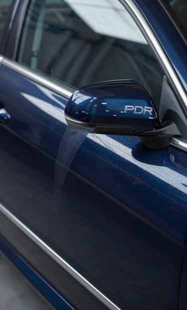 Close-up of a professional PDR line board reflecting perfectly straight lines on a restored car door, showcasing the quality of the repair. Lighting is focused and professional, highlighting a deep navy car surface #0A1E3C.