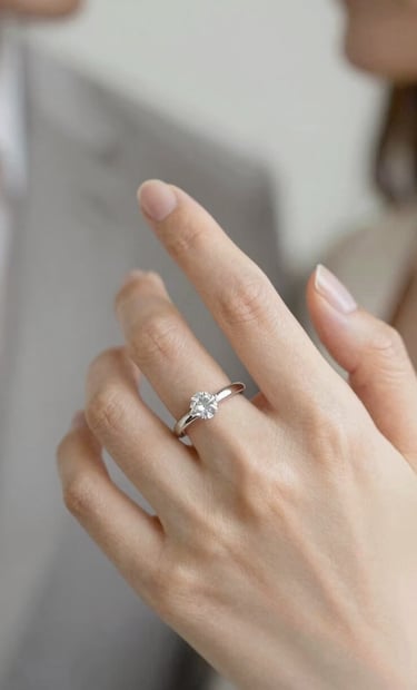 A close-up, artistic shot of a couple's interlaced fingers with a focus on an elegant engagement ring. The lighting is soft and golden, with a contemporary flair and a palette featuring #CFC7BB and #F7F5F0. Authentic and intimate atmosphere.