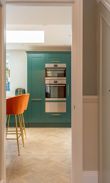 green howden kitchen, orange bar stools, paraquet flooring