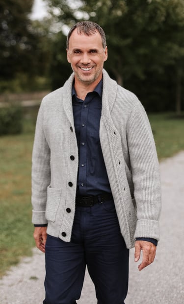 Martin Doucet souriant, debout à l’extérieur en tenue professionnelle décontractée. - Célébra.ca