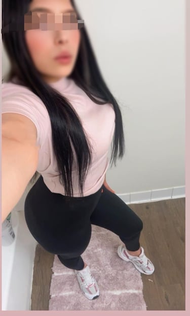 a woman with long hair and a pink shirt