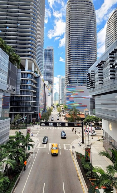 Una bulliciosa calle de la ciudad de Brickell, Miami, con modernos rascacielos y tráfico urbano.