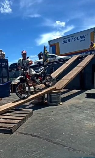 a man is standing on a ramp with a motorcycle