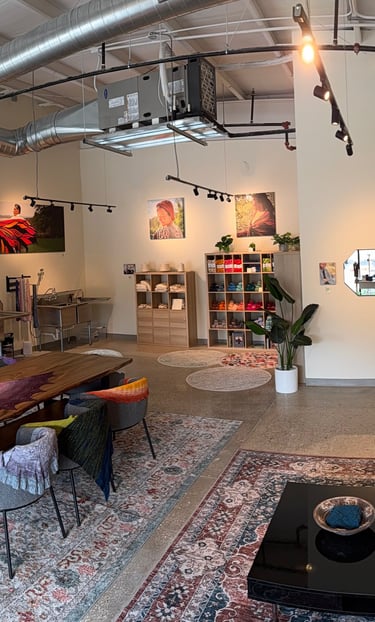 A panoramic image of a yarn shop with communal space to work.