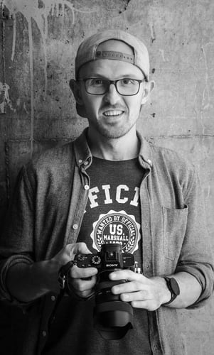Vincent Dumont tiens une caméra. La photo est noir & blanc
