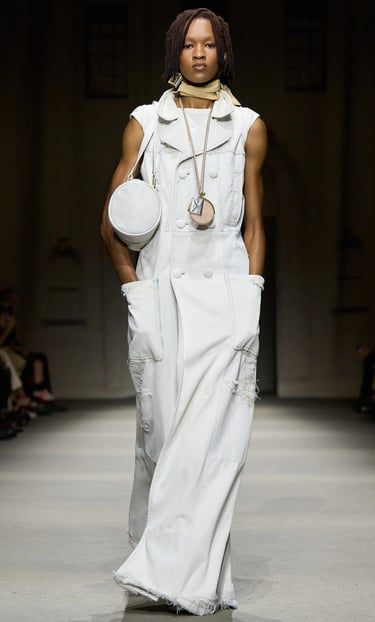 White sleeveless coat dress with round bag on Coach SS26 runway.
