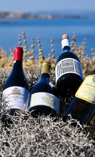 four bottles of greek wine on a grassy area