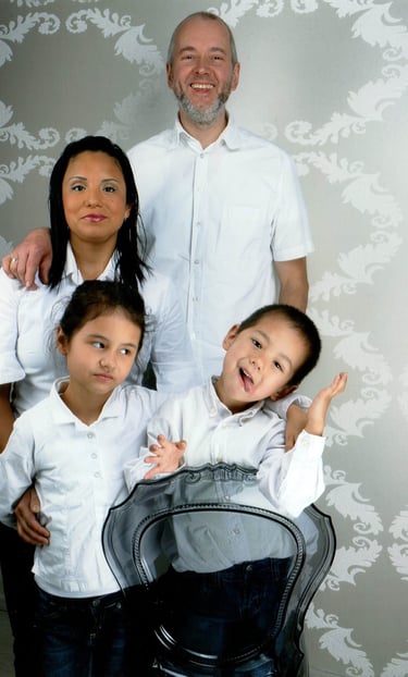 Jörg Grube mit Frau und zwei Kindern, alle mit weißem Hemd und schwarzer Hose