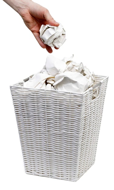 hand throwing rubbish in waste paper bin