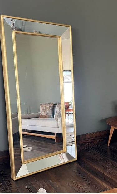 a mirror mirror in a room with a couch and a table