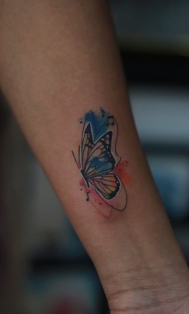 Butterfly tattoo with music notes watercolor fill on arm by Dudo’s Hyderabad