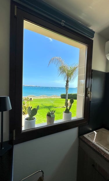 Panoramic sea view from kitchen window with palm tree and garden in Siracusa, Sicily villa