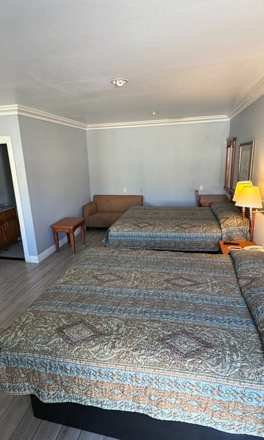 a motel room with two beds and a couch