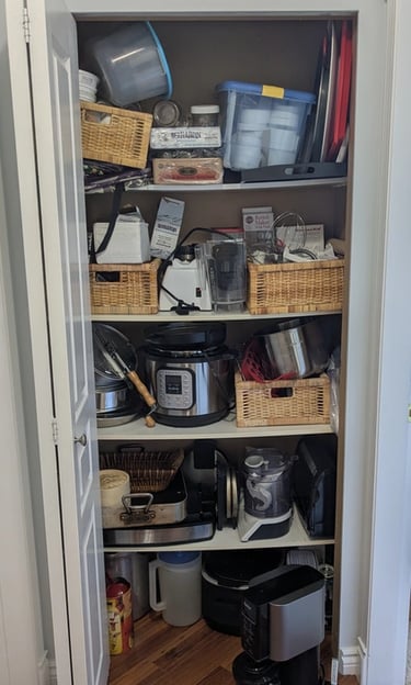 Old kitchenware closet with bowed melamine shelving