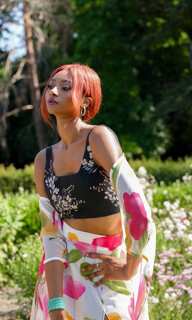 a woman model in a floral print dress and a black top