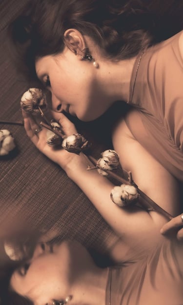 a woman laying on a couch with a flower in her hand and own reflection