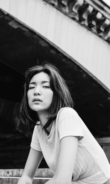 portrait féminin en noir et blanc regardant l'objectif en extérieur