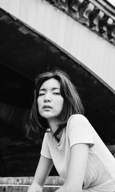 portrait féminin en noir et blanc regardant l'objectif en extérieur