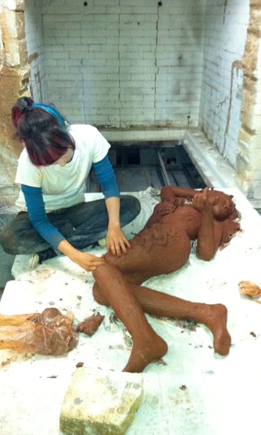 Girl sculpting a ceramic girl in a huge kiln