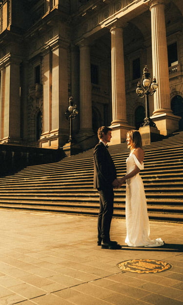 Elegant wedding couple at Parliament House Melbourne captured in cinematic golden light.
