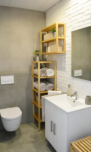 Reforma de baño con microcemento y ladrillo caravista blanco, realizado por los mejores interioristas de Valencia