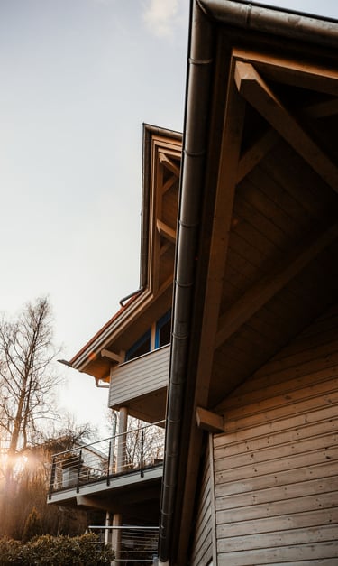 a house with a large wooden deck and a balcony with a view of the sun