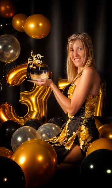 a woman holding a cake with a golden birthday cake