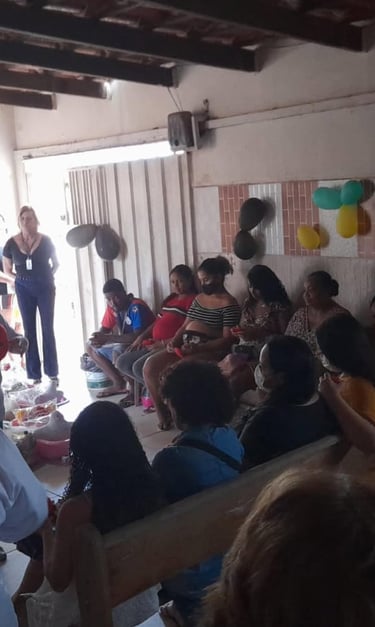 A community health workshop for pregnant women and families seated in a decorated room.