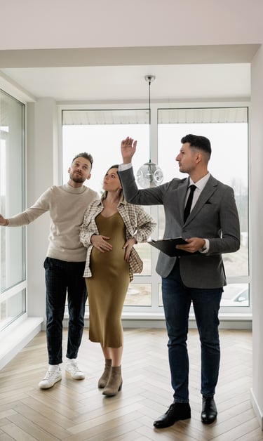 A real estate agent showing a modern new apartment to a young pregnant couple.