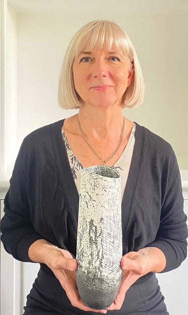 Rebecca Thomas holding a black and white ceramic vase