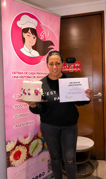 Mujer sonriente sosteniendo un pastel decorado con flores y un diploma de participación en un curso 