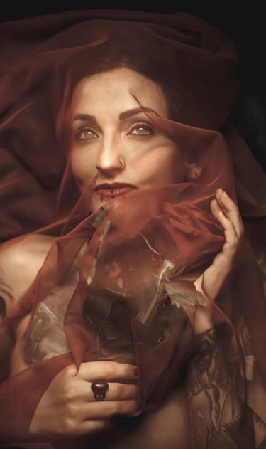 a woman with tattoo in a red dress with a veil on her head holding a red rose