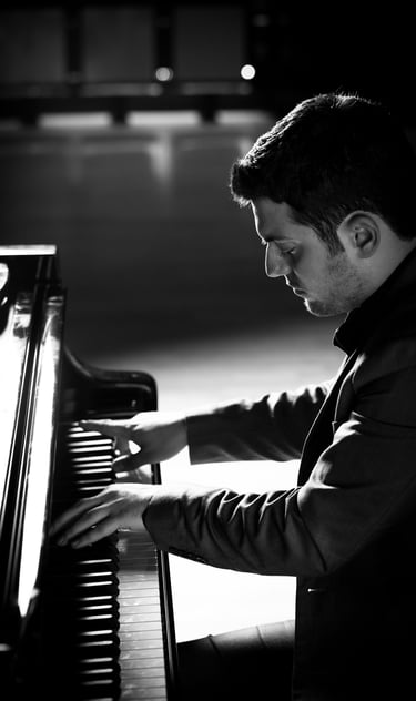 Stathis Chomatsas playing piano in a concert hall during a photoshoot