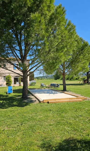 Vue sur la maison d'hôtes la Ramade et son terrain de pétanque.