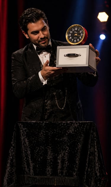 Professional magician in a tuxedo performing a stage magic trick with Tommy Wonder Nest of Boxes