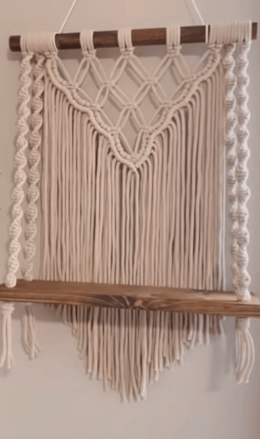 a macrame hanging from a wooden shelf