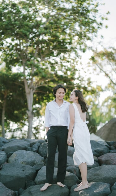 Intimate couple standing on rock formation at Novotel Bali Benoa in Tanjung Benoa Bali.