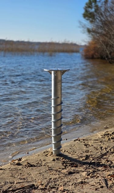 Pieu métallique dans le sable qui remplace un plot béton