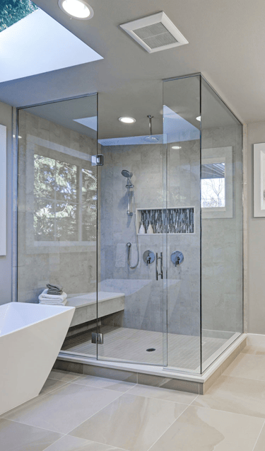 Cozy bathroom with warm lighting, a freestanding tub, and elegant tile work.