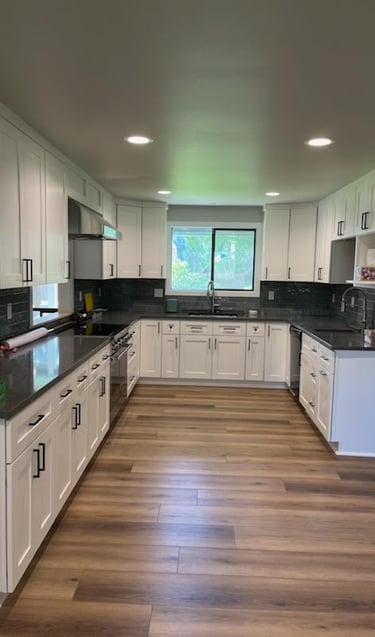 Vinyl Plank flooring, remodeled kitchen with white cabinets and gray counter tops