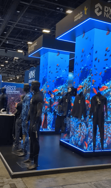 scuba dive mannequins in front of big convention columns showing  a dive video