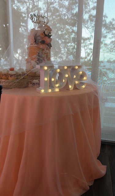 a table with a table cloth and a cake and a love sign