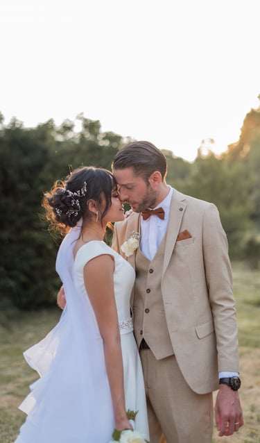 un couple de mariés s'enlaçant debout au coucher du soleil