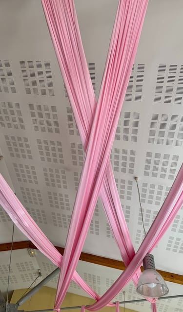 a ceiling with pink ribbon tied to a ceiling