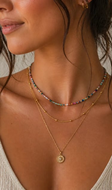 A woman wearing a layered gold necklace set with a colorful beaded choker and a dainty sun pendant.