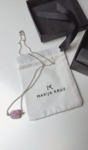 pakabukas su rausvu akmeniu šalia marija kruz vardinio maišelio