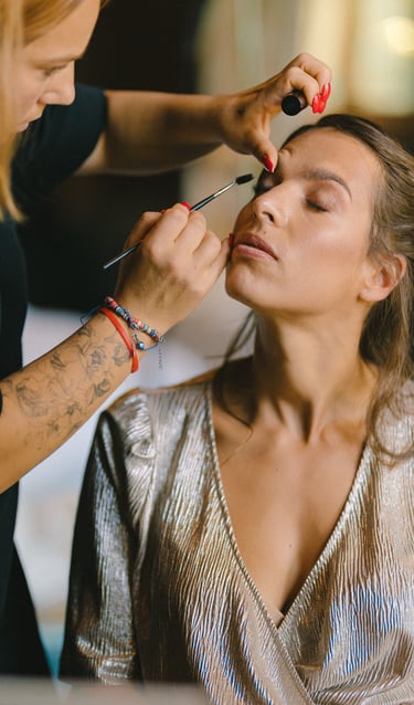 une femme se fait maquiller par une maquilleuse professionnelle