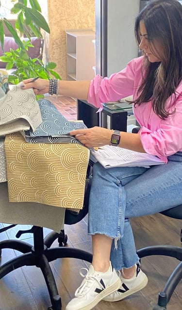 Sigal, founder of Solo Home Decor, selects fabrics while designing custom furniture.